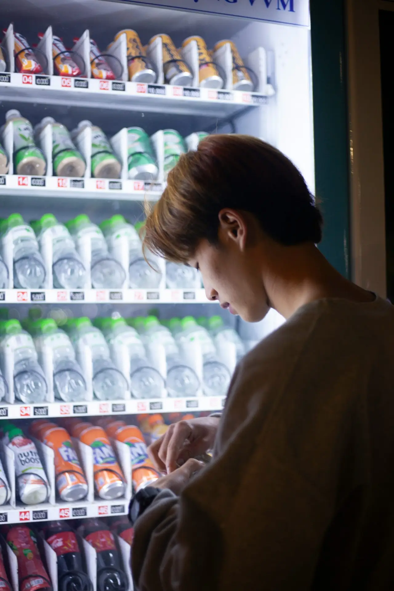 man looking for coins vending machine